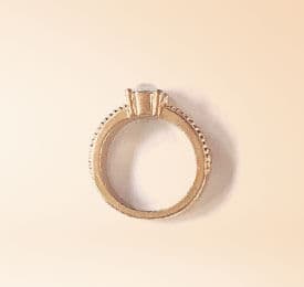 Yellow Gold And Dimond Ring photographed on a plain background